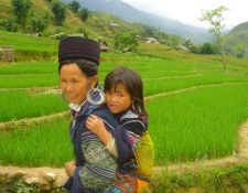 Sdostasien, Vietnam: Von den Bergstmmen bis zum Mekongdelta - Mutter mit ihrem Kind vor einem Reisfeld